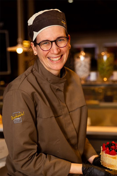 Cocinera sonriendo satisfecha en su puesto de trabajo