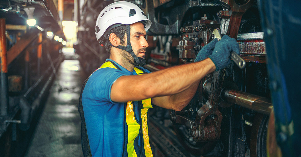 Un profesional industrial utiliza un destornillador para manipular la maquinaria