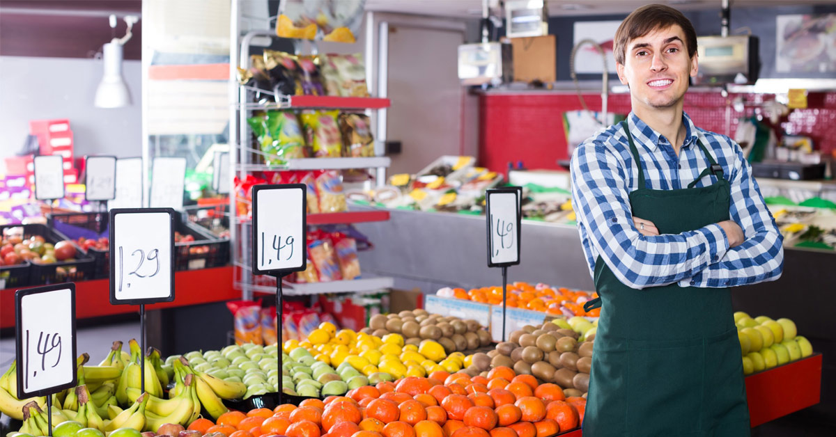 Employé du rayon fruits souriante dans un supermarché