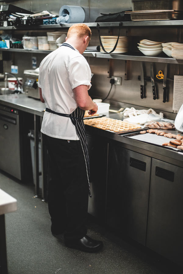 Pastry chef wearing rubber, slip-resistant kitchen shoes filling pastries