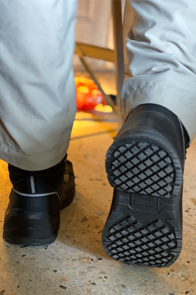 Man walking next to ladder wearing slip-resistant safety boots