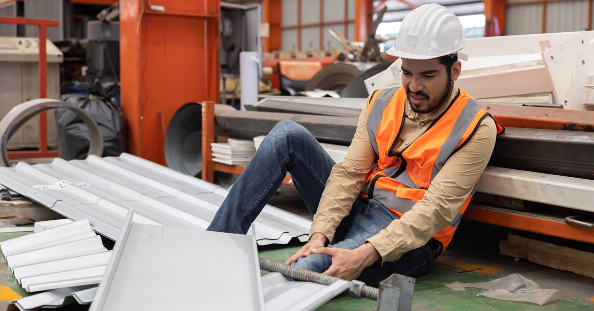 An industrial engineer sitting on the floor after sheet metal accident occurred