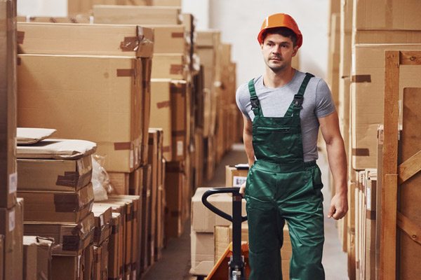 Worker pulling boxes with trolley to assist with manual handling task