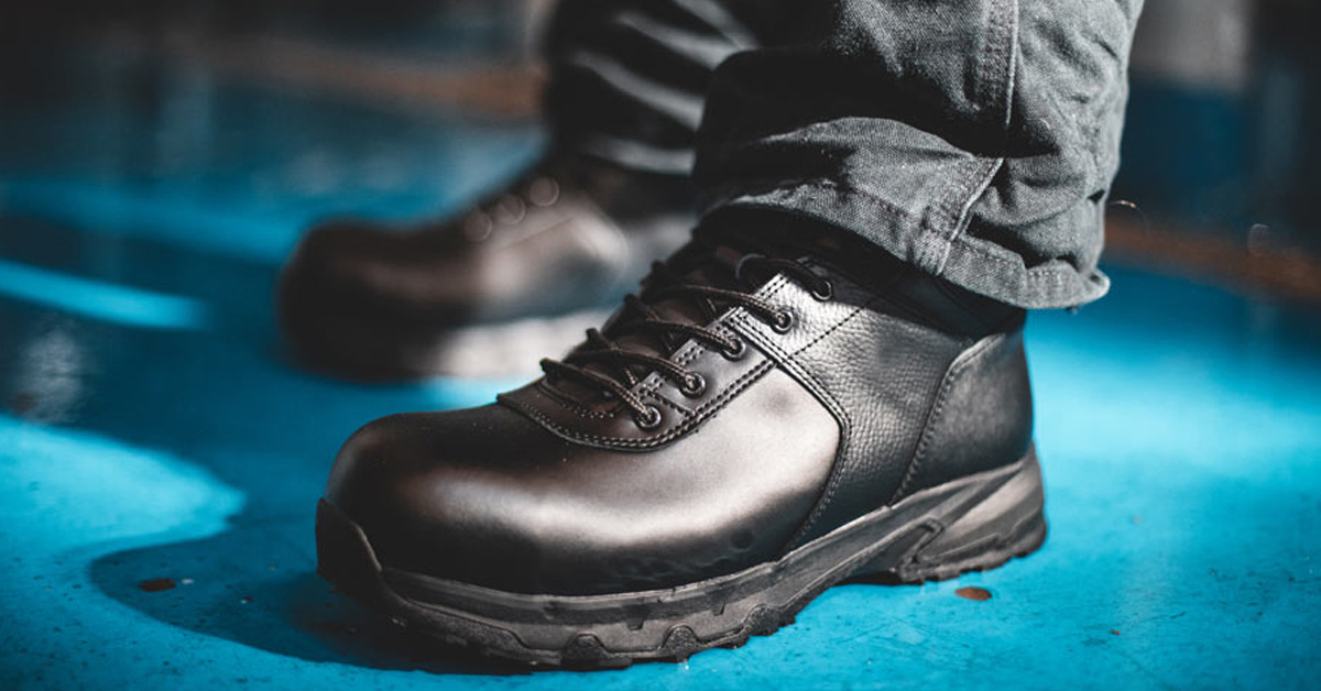 Worker wearing Shoes For Crews style Engineer in black standing on blue linoleum floor